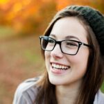 Headshot photography of a young woman with glasses and hat