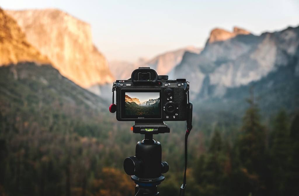 Camera tripod, set up in the mountains, as basic equipment for landscape photography