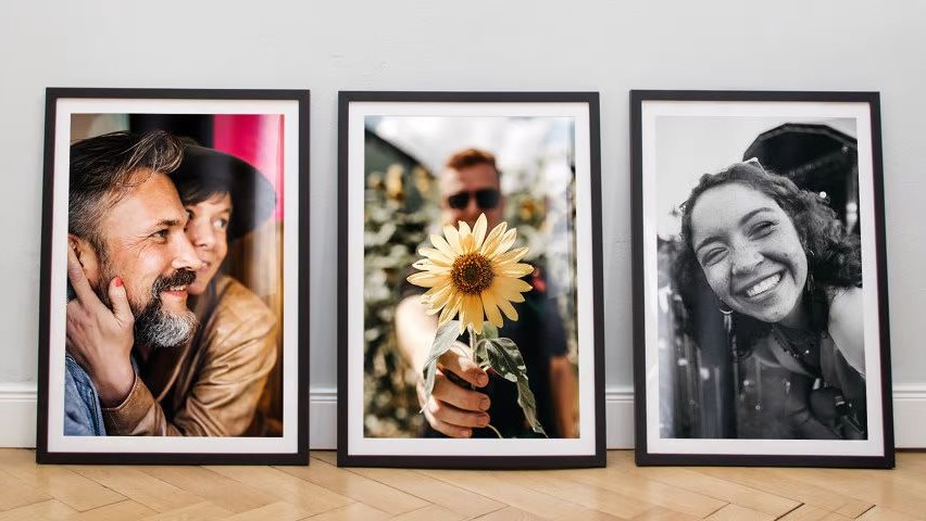 Three framed portrait pictures with different motifs, placed next to each other on the floor