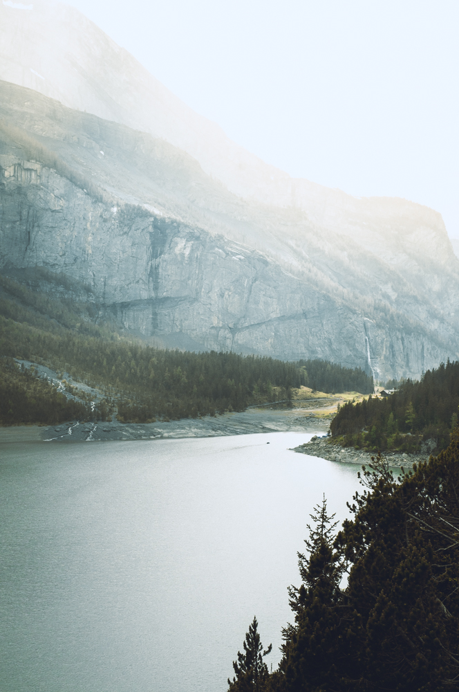 Landscape photo of the mountain lake Oeschinensee with a small boat floating on the lake