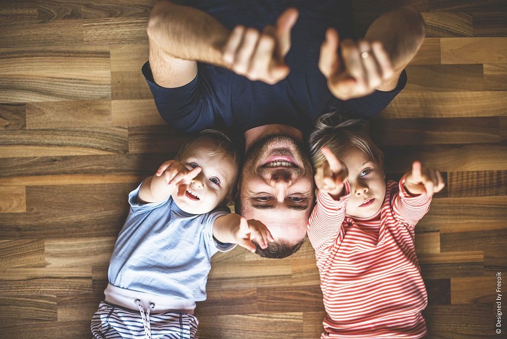 Family picture ideas: Photo of a dad and his kids lying on the floor taken from bird's-eye view.
