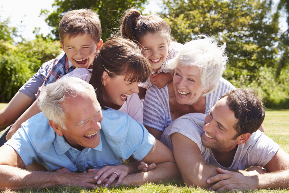 Family photoshoot: Group photo of children and their grandparents playing in the garden and laughing.