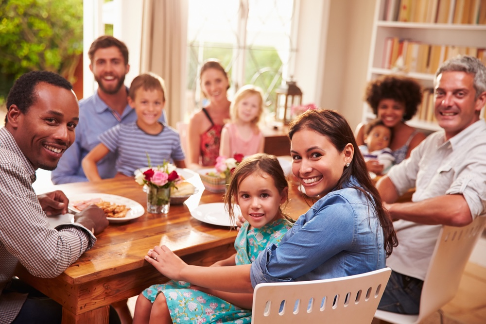 Family christmas picture ideas: A family during lunch looking into the camera spontaneously.